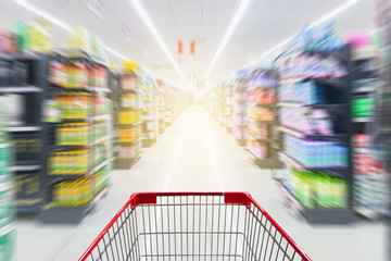 Supermarket aisle with empty red shopping cart