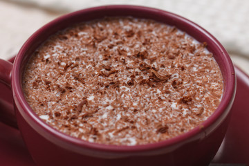 Milk chocolate in a cup on a saucer against a background of a sc