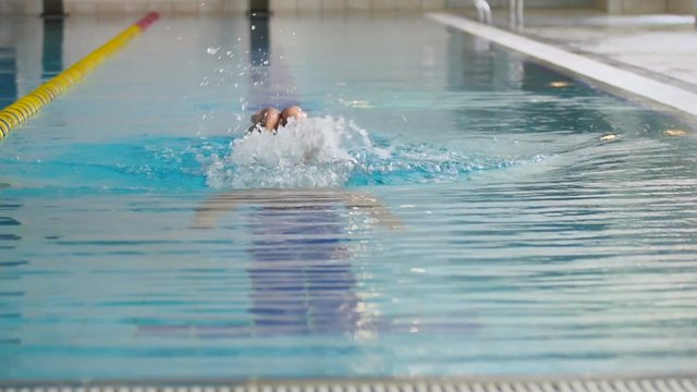 Young sportsman swimming under the water in the swimming pool