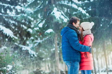 woman and man having fun in winter forest