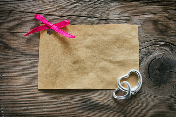 paper tag with a pink bow, two silver heart