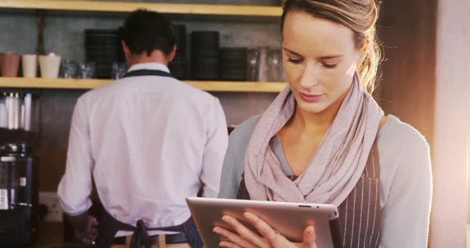 Waiter and waitress looking back and talking to each other while working in cafe 4k