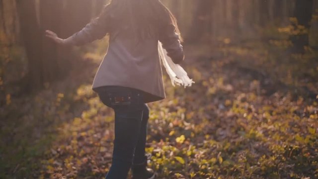 Frightened little girl running in the dense forest and suddenly stops in the bright sunshine. Scary story, danger. Outside shooting of lost child in the woods.