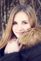 Portrait of Young smiling girl with long hair in winter park