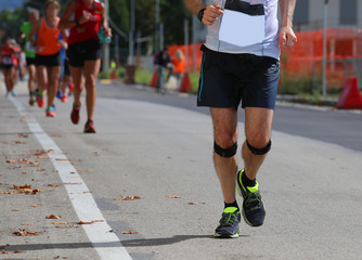 athletic runner with elastic band at the knee running fast durin