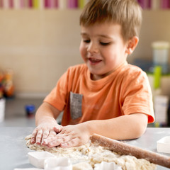 Fototapeta na wymiar Kid is baking bread. He is dirty in flour.