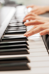 Fototapeta na wymiar Closeup of hands playing piano. Music and hobby concept