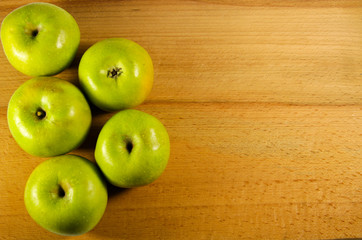 Fresh green apples on wooden background