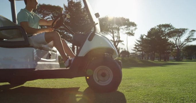 Golfer driving in his golf buggy at golf course