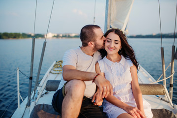 Young beautiful married couple in love at the yacht on vacation.