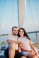 Fototapeta na wymiar Young beautiful married couple in love at the yacht on vacation.