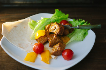 Seitan on white plate with the vegetables