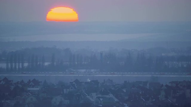 Aerial view of the suburbs of winter foggy sunset with a big sun
