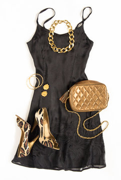 Christmas Party Outfit. Cocktail Dress Outfit, Night Out Look On White Background. Little Black Dress, Gold Bag, Leopard Shoes, Gold Necklace. Flat Lay, Top View