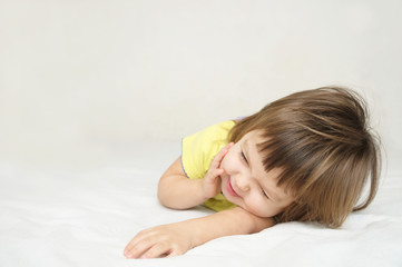 Obraz na płótnie Canvas happy little girl having fun lying on bed