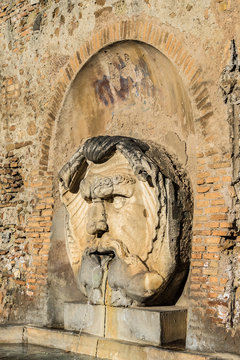 Mask fountain in courtyard of Santa Sabina Basilica. Rome, Italy