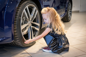Small girl in car exhibition room