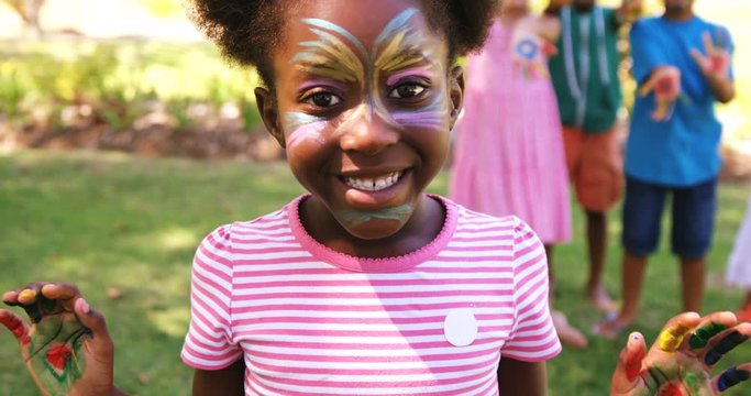 Portrait of girl with painted face and hands in park 4k