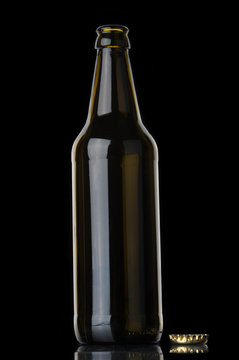 Empty beer bottle and cork  on black background