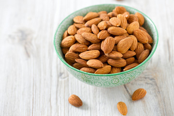 almonds in a bowl on wooden surface