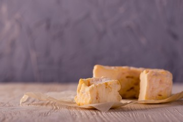 Portion of golden camembert on white wooden board