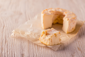 Portions of golden camembert cheese on white board