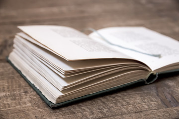 Opened old book with  rope laying on wooden surface