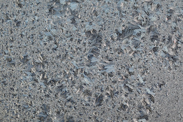 Frozen glass, frost at transparent surface, closeup textured background
