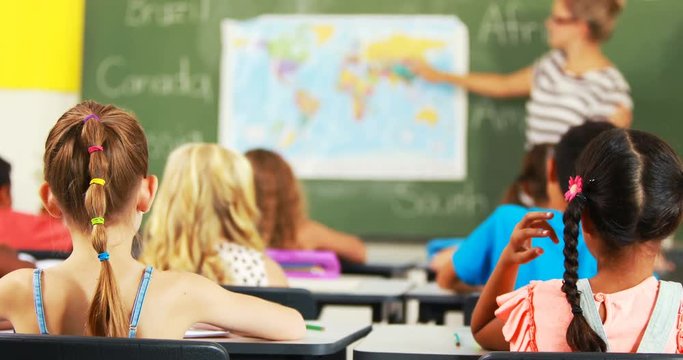 School kids raising hand in classroom at school 4k