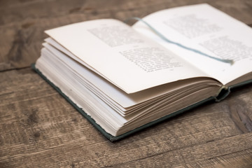 Opened old book with  rope laying on wooden surface