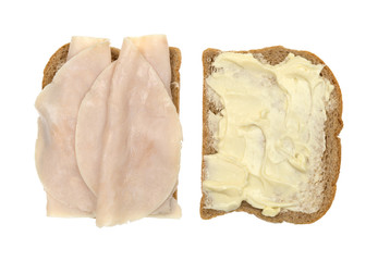 Turkey breast sandwich on wheat bread open top view isolated on a white background.