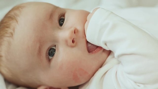 Four month old baby's face with a trace of lipstick kiss.