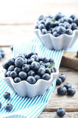 Ripe and tasty blueberries on grey wooden table