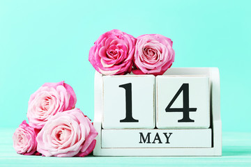 Beautiful pink roses with cube calendar on green background