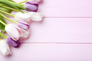 Bouquet of tulips on pink wooden table