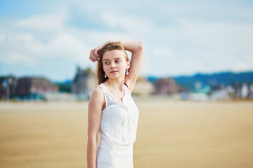 Fototapeta na wymiar Beautiful young woman enjoying sun on a sand beach