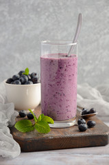 Blueberry and banana smoothie with oatmeal on the rustic wooden table, selective focus