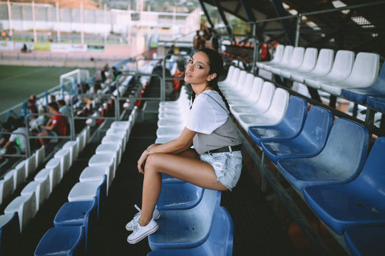 Portrait of young woman on stadium seat