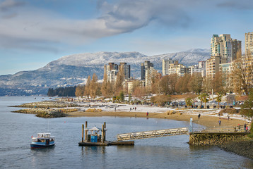 English Bay Winter, Vancouver. Sunset Beach on English Bay. In the background are the snowcapped Coast Mountains. Vancouver, British Columbia, Canada.
