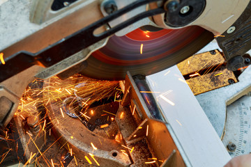 Close-up of worker cutting metal with grinder. Sparks while grinding iron. Low depth  focus