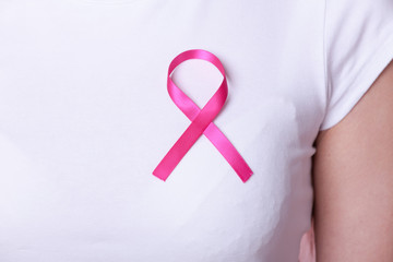 Pink ribbon on woman chest to support breast cancer cause