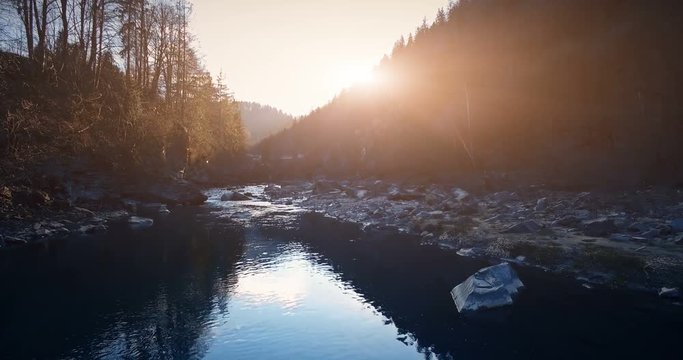 4K Aerial Drone View: Low Flight over calm beautiful mountain river in sunset. Pine tree forest around. Carpathian Mountains, Ukraine, Europe. Majestic nature landscape. Beauty world. Vintage toning