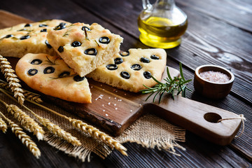 Fototapeta na wymiar Traditional Italian Focaccia with black olives and rosemary