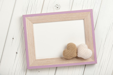 Two crochet hearts and blank wooden frame