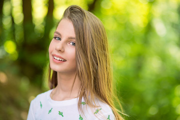 Woman smiling with perfect smile and white teeth in a park and looking at camera.