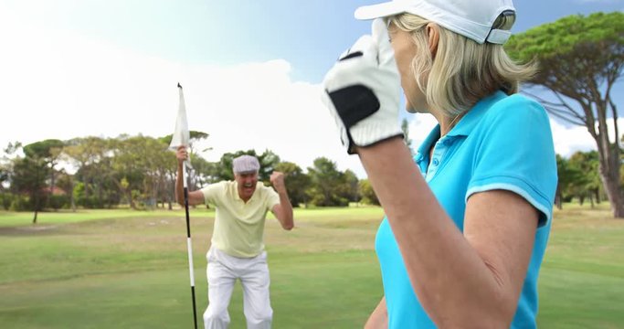 Excited golf players playing together at golf course 