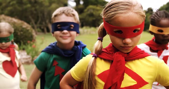 Portrait of group of kids pretending to be a super hero in the park 4k