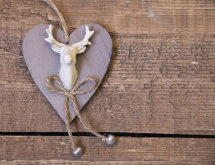 Wooden vintage heart with deer image for an interior on wooden surface