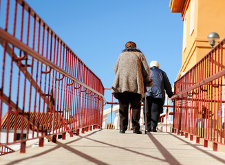 Two old ladies climbing a ramp with difficulty