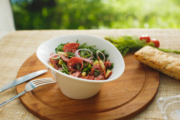 salad in white bowl on a background of nature